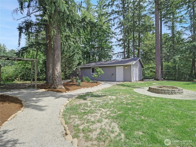 15518SE 304th Pl, Kent, WA 98042 - view of green lawn featuring a fire pit, an outdoor structure, gravel driveway, and a garage