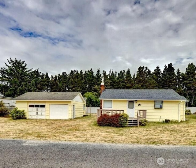 1215 199th Pl, Long Beach, WA 98631 - view of front of home with a garage, an outdoor structure, a chimney, a wooden deck, and a front yard