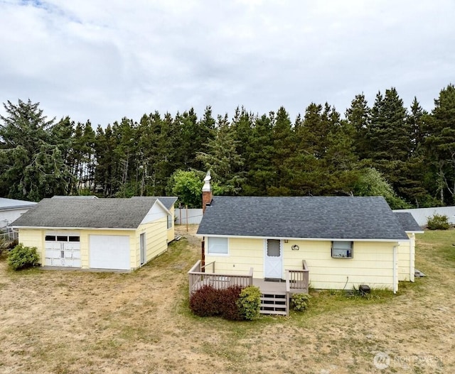 1215 199th Pl, Long Beach, WA 98631 - view of front of home with a wooden deck, a garage, an outdoor structure, a front lawn, and roof with shingles