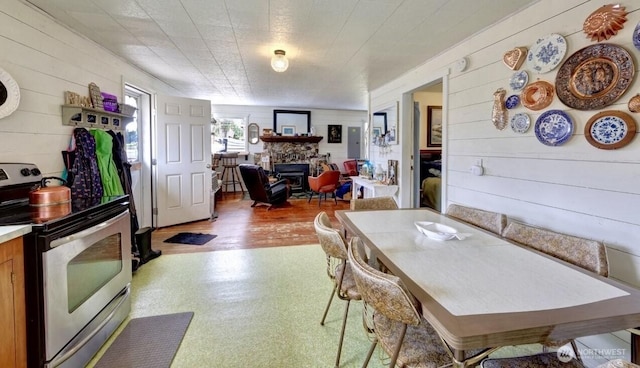 1215 199th Pl, Long Beach, WA 98631 - dining space with wood walls, a fireplace, and light flooring