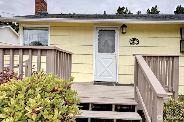 1215 199th Pl, Long Beach, WA 98631 - entrance to property featuring a chimney, a deck, and a shingled roof