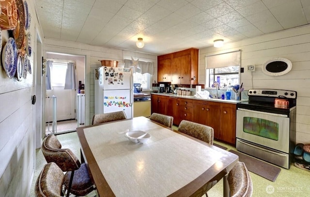 1215 199th Pl, Long Beach, WA 98631 - kitchen with white appliances, brown cabinets, light countertops, and wooden walls