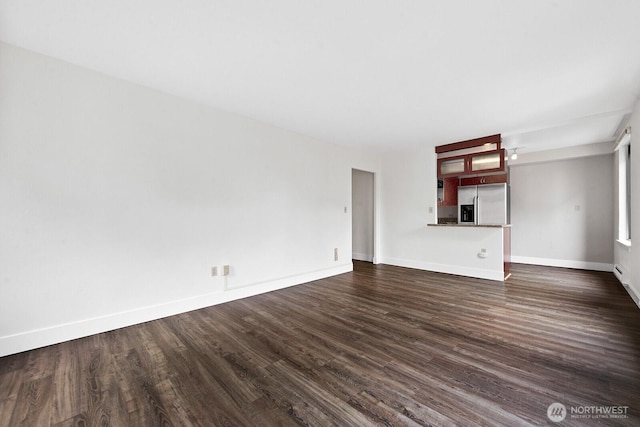 1105 Spring St Unit 407, Seattle, WA 98104 - unfurnished living room featuring dark wood-type flooring and baseboards