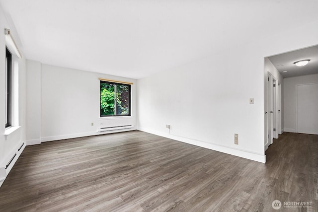 1105 Spring St Unit 407, Seattle, WA 98104 - empty room with wood finished floors and a baseboard radiator