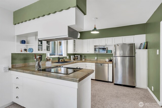 8554 16th Ave NW, Seattle, WA 98117 - kitchen with stainless steel appliances, open shelves, a peninsula, white cabinets, and dark aggregate flooring