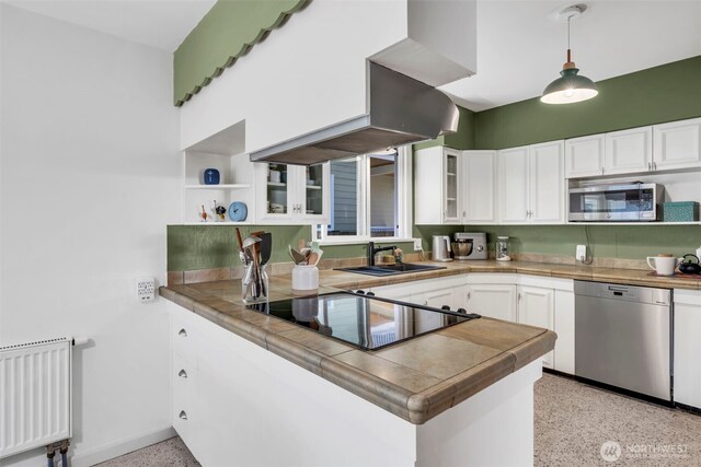 8554 16th Ave NW, Seattle, WA 98117 - kitchen featuring appliances with stainless steel finishes, radiator, dark speckled floor, a peninsula, and open shelves