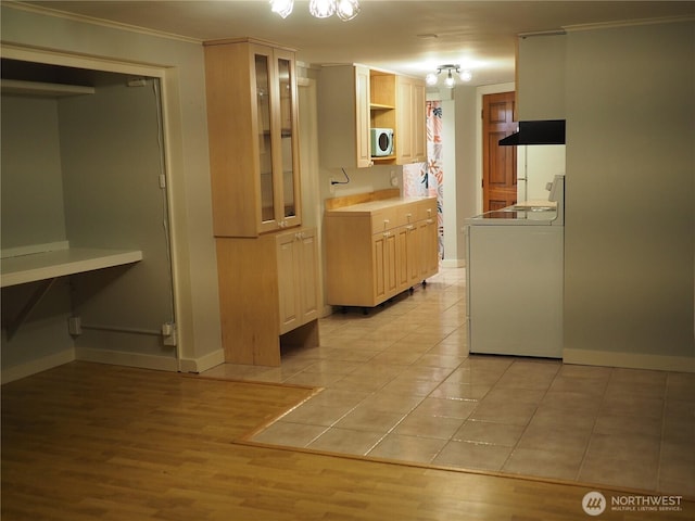 8554 16th Ave NW, Seattle, WA 98117 - kitchen featuring white microwave, crown molding, under cabinet range hood, glass insert cabinets, and light tile patterned floors