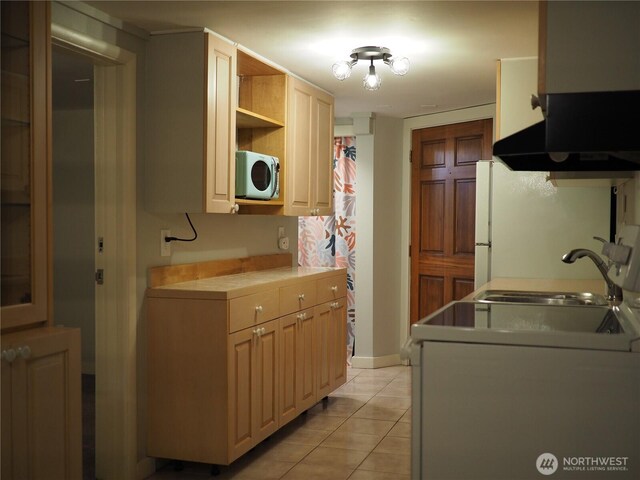 8554 16th Ave NW, Seattle, WA 98117 - kitchen with under cabinet range hood, freestanding refrigerator, light tile patterned floors, tile counters, and open shelves