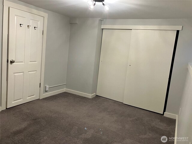 8554 16th Ave NW, Seattle, WA 98117 - unfurnished bedroom with dark colored carpet and a closet