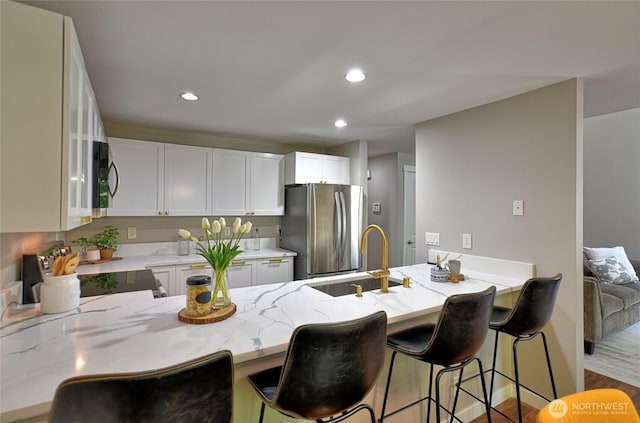 3030 128th Ave SE Unit 6, Bellevue, WA 98005 - kitchen featuring freestanding refrigerator, a peninsula, light stone counters, recessed lighting, and white cabinetry