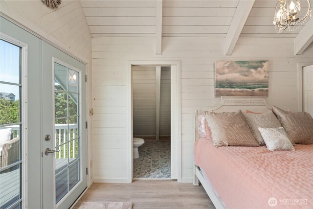 195 Ocean Shores Blvd SW, Ocean Shores, WA 98569 - bedroom with access to exterior, wooden walls, light wood-style floors, a chandelier, and french doors