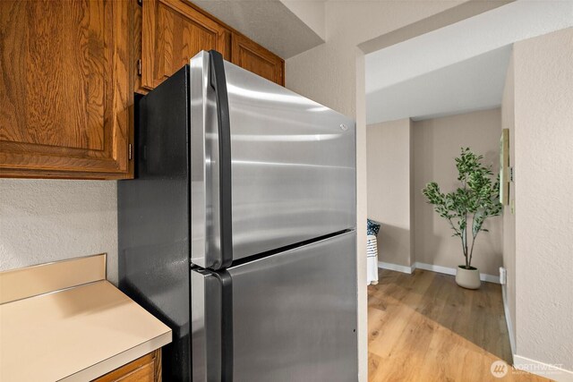 140 Summit Ave N Unit A6, Kent, WA 98030 - kitchen with freestanding refrigerator, brown cabinets, light wood-type flooring, and light countertops