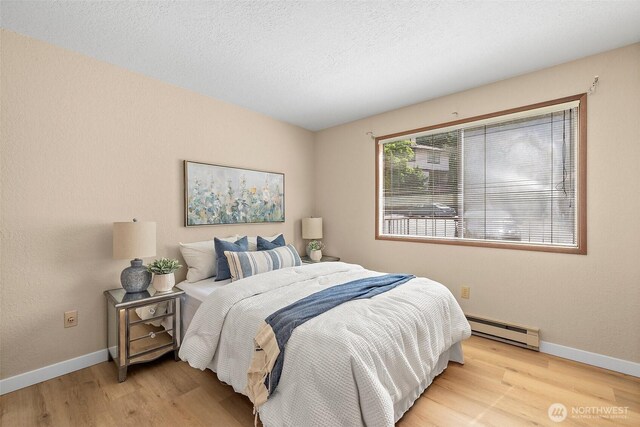 140 Summit Ave N Unit A6, Kent, WA 98030 - bedroom with a baseboard radiator, wood finished floors, and a textured ceiling