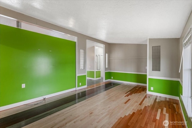 3001 S 288th Unit 89, Federal Way, WA 98003 - unfurnished room with wood finished floors, baseboards, and a textured ceiling