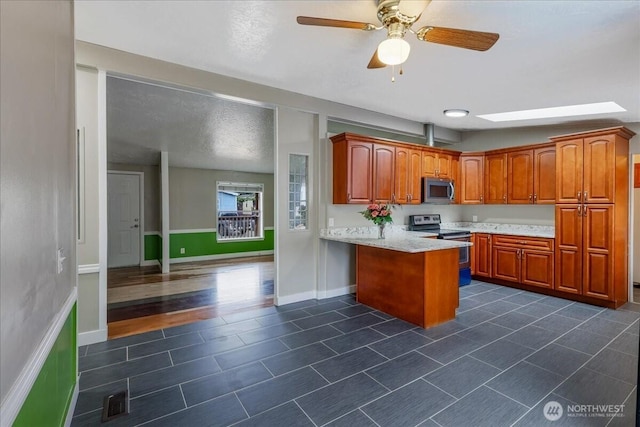 3001 S 288th Unit 89, Federal Way, WA 98003 - kitchen with stainless steel appliances, a peninsula, dark tile patterned floors, ceiling fan, and brown cabinets