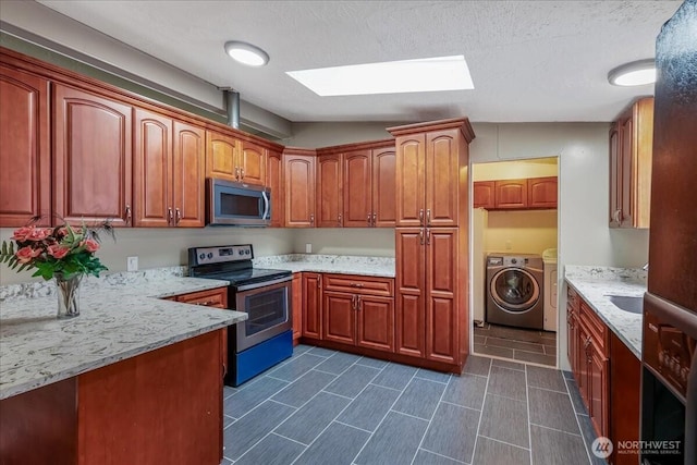 3001 S 288th Unit 89, Federal Way, WA 98003 - kitchen with stainless steel appliances, washing machine and dryer, light stone countertops, and a textured ceiling