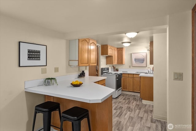 3604 SW Graham St, Seattle, WA 98126 - kitchen with white range oven, a peninsula, a breakfast bar, and light countertops