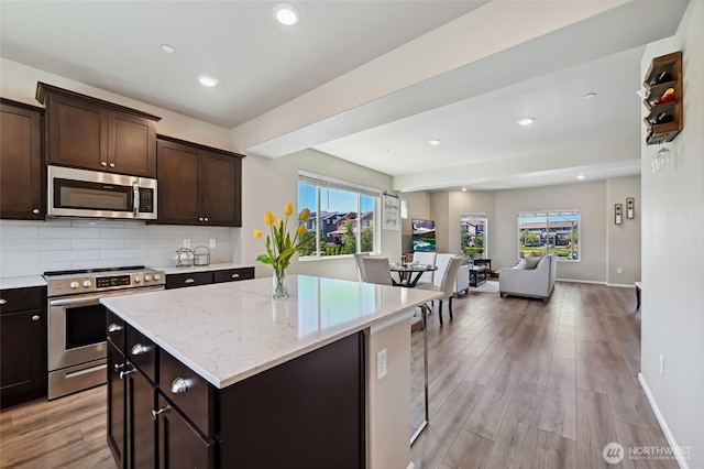 17401 118th Avenue Ct E Unit A, Puyallup, WA 98374 - kitchen featuring appliances with stainless steel finishes, healthy amount of natural light, open floor plan, light wood-type flooring, and recessed lighting