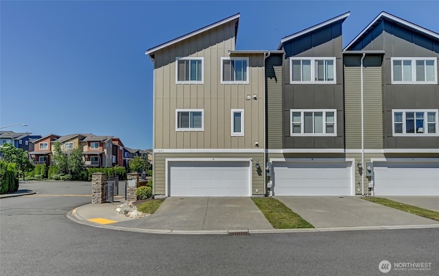 17401 118th Avenue Ct E Unit A, Puyallup, WA 98374 - view of front facade with board and batten siding, an attached garage, a residential view, and driveway
