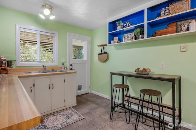 13743 36th Ave NE, Seattle, WA 98125 - kitchen with white cabinets, tile patterned floors, light countertops, and open shelves
