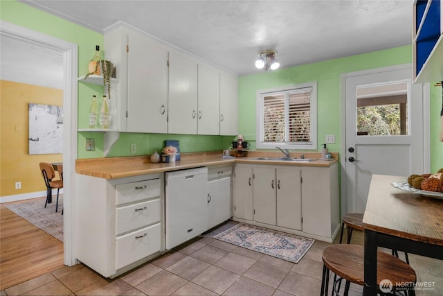 13743 36th Ave NE, Seattle, WA 98125 - kitchen with white dishwasher, white cabinetry, light countertops, light tile patterned floors, and crown molding