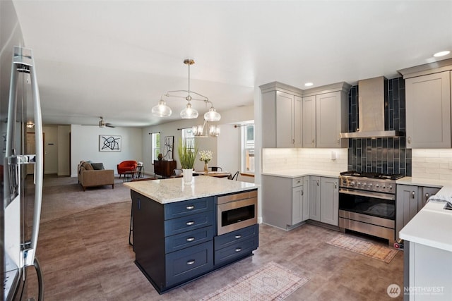 29664 127th Pl SE, Auburn, WA 98092 - kitchen featuring high end range, wall chimney exhaust hood, open floor plan, tasteful backsplash, and gray cabinetry