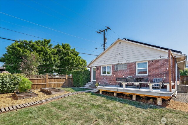 4603 15th Ave S, Seattle, WA 98108 - back of property with a vegetable garden, brick siding, and a wooden deck