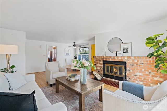 4603 15th Ave S, Seattle, WA 98108 - living room with light wood-type flooring, a brick fireplace, and a ceiling fan