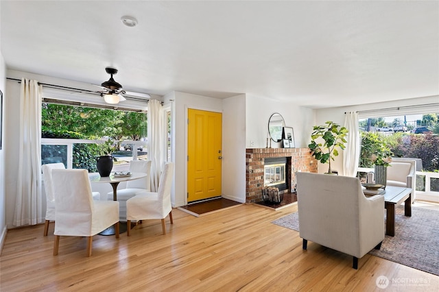 4603 15th Ave S, Seattle, WA 98108 - living area featuring light wood-type flooring, a ceiling fan, and a brick fireplace