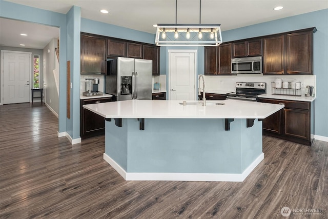 15527 E 82nd Ave E, Puyallup, WA 98375 - kitchen featuring appliances with stainless steel finishes, dark brown cabinets, light countertops, dark wood-style floors, and recessed lighting