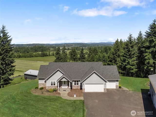 42811 Newaukum Valley Rd, Chehalis, WA 98532 - view of front of home featuring an attached garage, asphalt driveway, a front lawn, stone siding, and a forest view