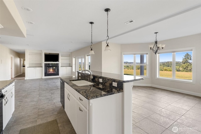 42811 Newaukum Valley Rd, Chehalis, WA 98532 - kitchen with black dishwasher, a glass covered fireplace, a center island with sink, white cabinets, and a chandelier