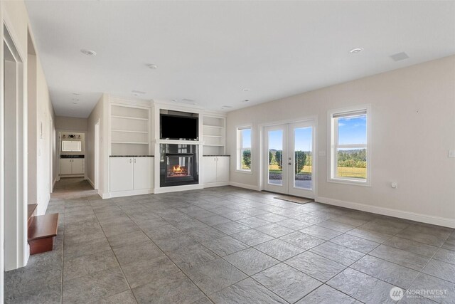 42811 Newaukum Valley Rd, Chehalis, WA 98532 - unfurnished living room featuring built in features, french doors, a glass covered fireplace, and recessed lighting