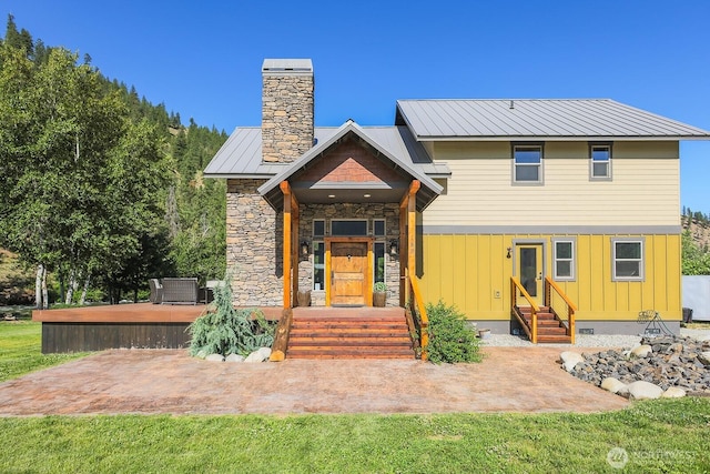 180 Country River Ln, Entiat, WA 98822 - view of front of house featuring entry steps, a chimney, a metal roof, stone siding, and board and batten siding