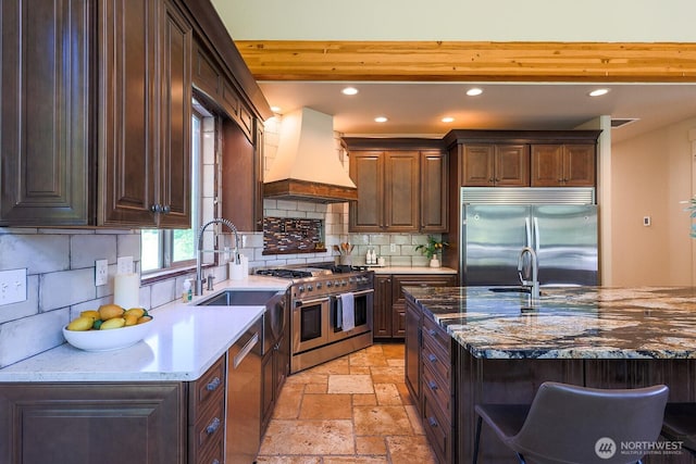 180 Country River Ln, Entiat, WA 98822 - kitchen featuring appliances with stainless steel finishes, custom exhaust hood, stone tile flooring, recessed lighting, and decorative backsplash