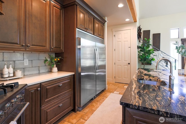 180 Country River Ln, Entiat, WA 98822 - kitchen with stainless steel built in fridge, stone tile flooring, recessed lighting, backsplash, and range with gas stovetop