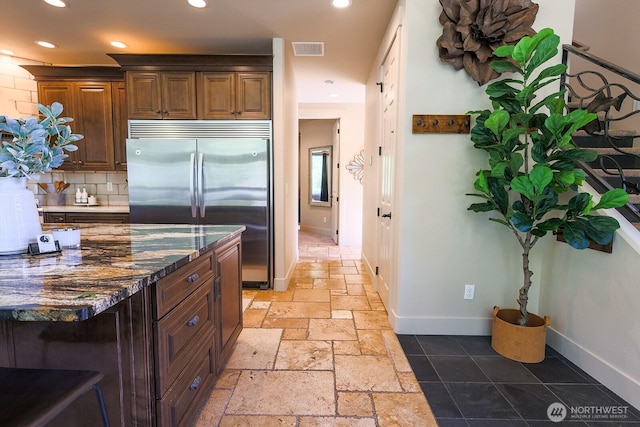 180 Country River Ln, Entiat, WA 98822 - kitchen featuring built in fridge, recessed lighting, stone tile floors, decorative backsplash, and dark stone counters