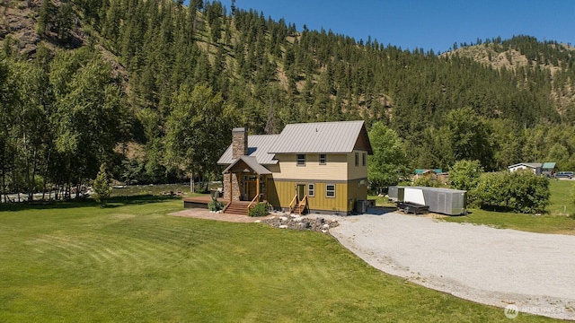 180 Country River Ln, Entiat, WA 98822 - view of front of house featuring a view of trees, a chimney, a metal roof, and a front yard