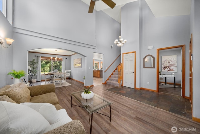 2502 218th St E, Spanaway, WA 98387 - living room with arched walkways, a chandelier, a high ceiling, stairs, and a ceiling fan