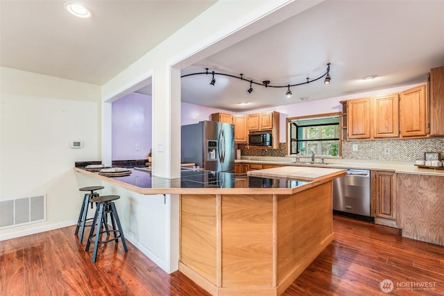 13617 436th Ave SE, North Bend, WA 98045 - kitchen featuring stainless steel appliances, a breakfast bar, dark wood-style floors, a peninsula, and recessed lighting
