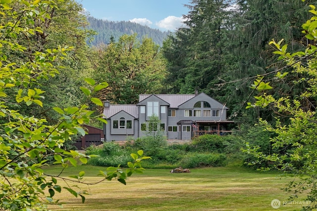 45908 SE Edgewick Rd, North Bend, WA 98045 - back of property featuring a forest view, a lawn, a metal roof, and a chimney
