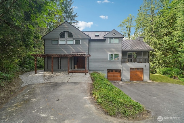 45908 SE Edgewick Rd, North Bend, WA 98045 - view of front facade featuring driveway, a garage, a metal roof, a chimney, and a balcony