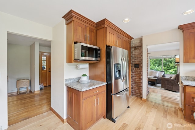 45908 SE Edgewick Rd, North Bend, WA 98045 - kitchen featuring appliances with stainless steel finishes, light wood-style floors, light stone counters, brown cabinets, and recessed lighting
