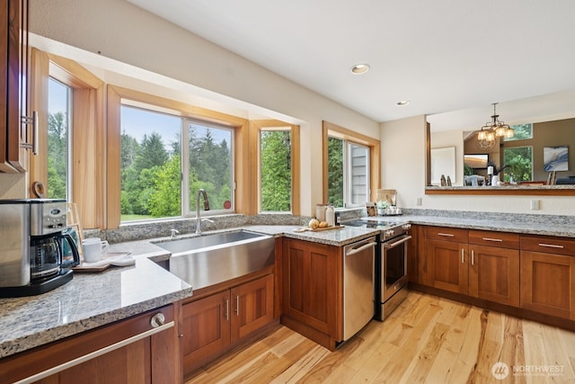 45908 SE Edgewick Rd, North Bend, WA 98045 - kitchen featuring dishwasher, light stone countertops, light wood-style floors, brown cabinetry, and recessed lighting