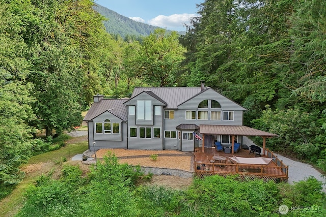 45908 SE Edgewick Rd, North Bend, WA 98045 - back of property with a wooded view, a metal roof, a deck, a chimney, and a standing seam roof