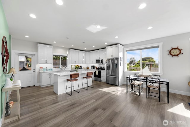 4123 Stuart Cir, Ferndale, WA 98248 - kitchen with stainless steel appliances, a center island, a breakfast bar area, light countertops, and white cabinets