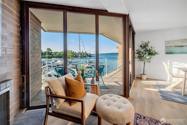 9500 Rainier Ave S Unit 303, Seattle, WA 98118 - living area with expansive windows, a water view, healthy amount of natural light, and wood finished floors