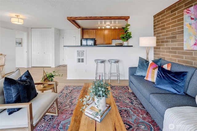 9500 Rainier Ave S Unit 303, Seattle, WA 98118 - living area featuring light wood finished floors and a textured ceiling