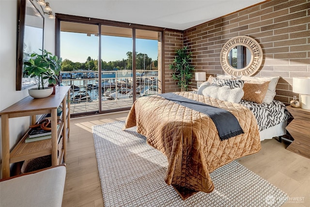 9500 Rainier Ave S Unit 303, Seattle, WA 98118 - bedroom with access to exterior, wood finished floors, multiple windows, and expansive windows