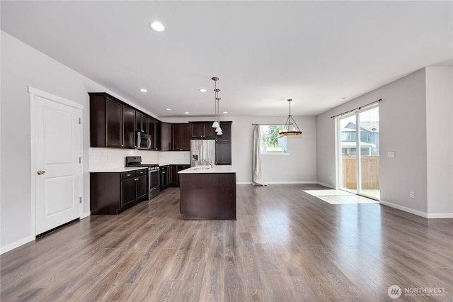 4236 SW Colbert Way, Port Orchard, WA 98367 - kitchen featuring appliances with stainless steel finishes, light countertops, dark brown cabinetry, baseboards, and wood finished floors